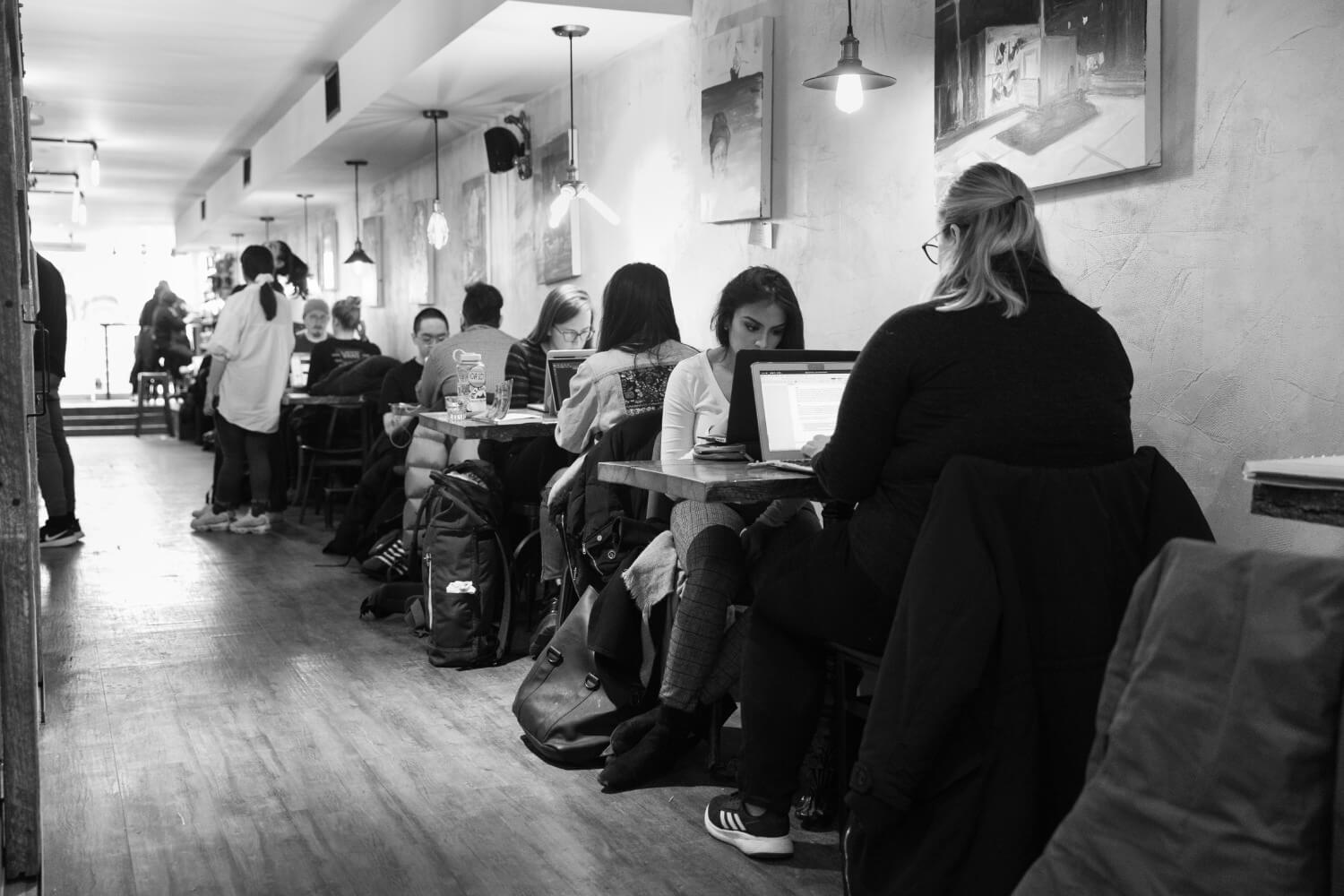 goldstruck people working at tables with laptops